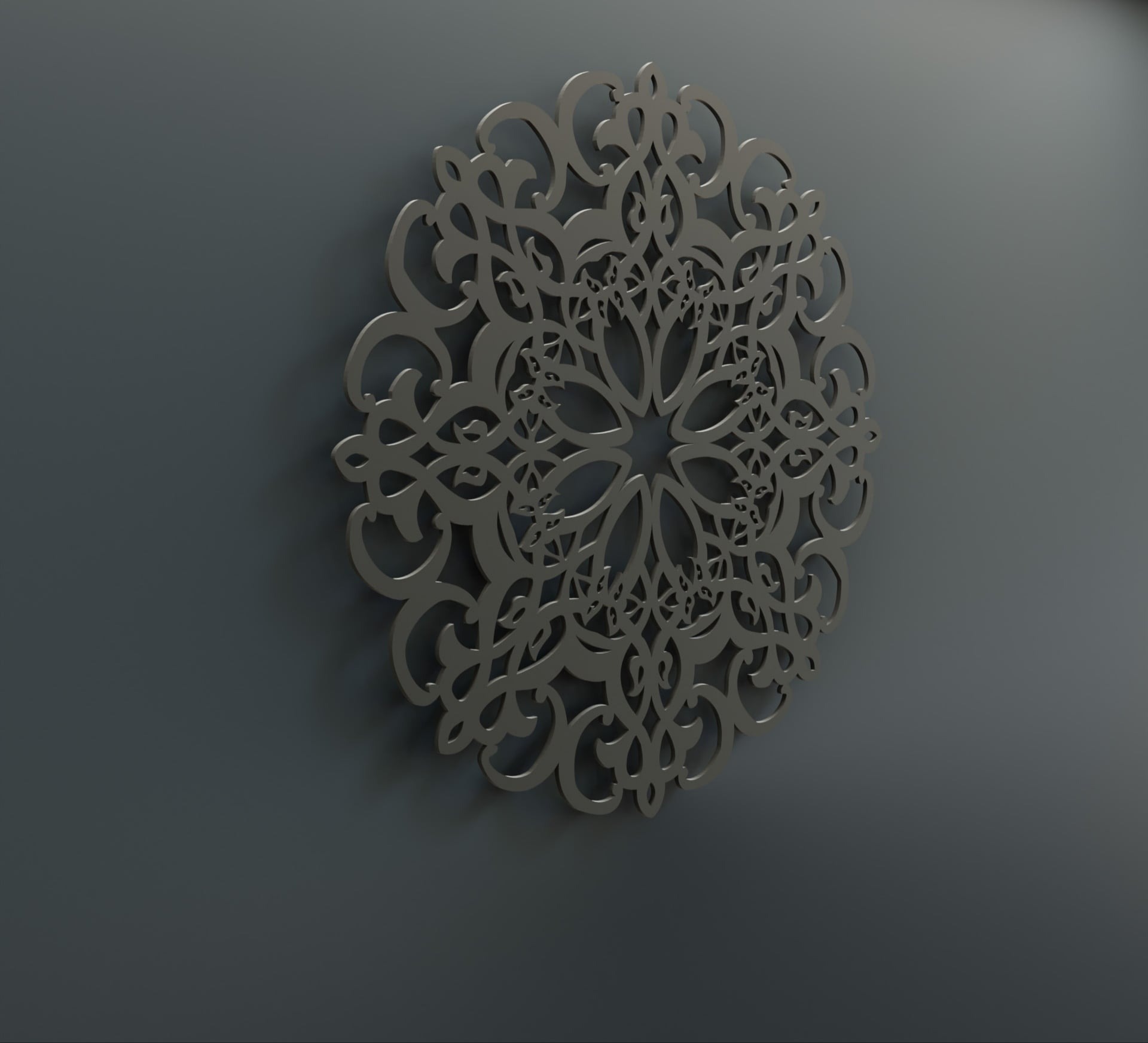 Dekoracyjna, metalowa mandala na szarej ścianie, z delikatnym cieniowaniem podkreślającym trójwymiarowość wzoru.