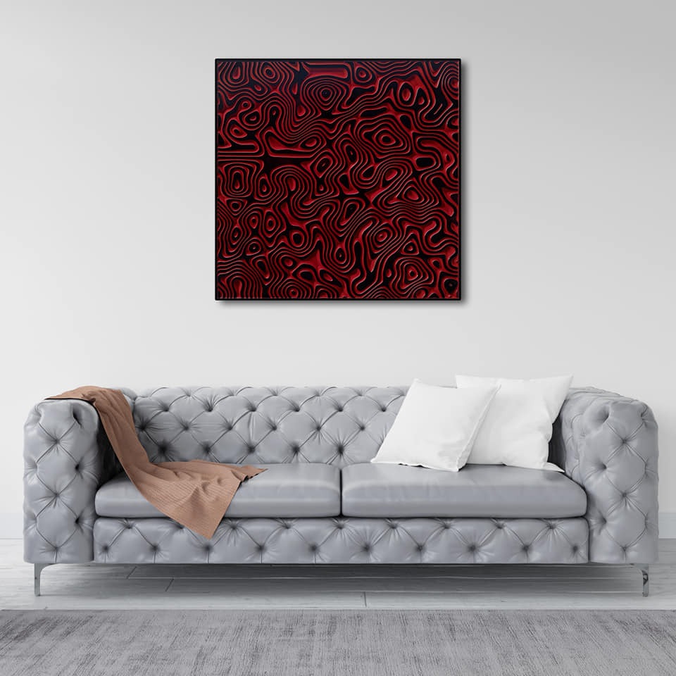Szary skórzany chesterfield z narzuconym beżowym pledem i białymi poduszkami, pod nim szary dywan, na ścianie abstrakcyjny obraz w czarno-czerwonej ramie.