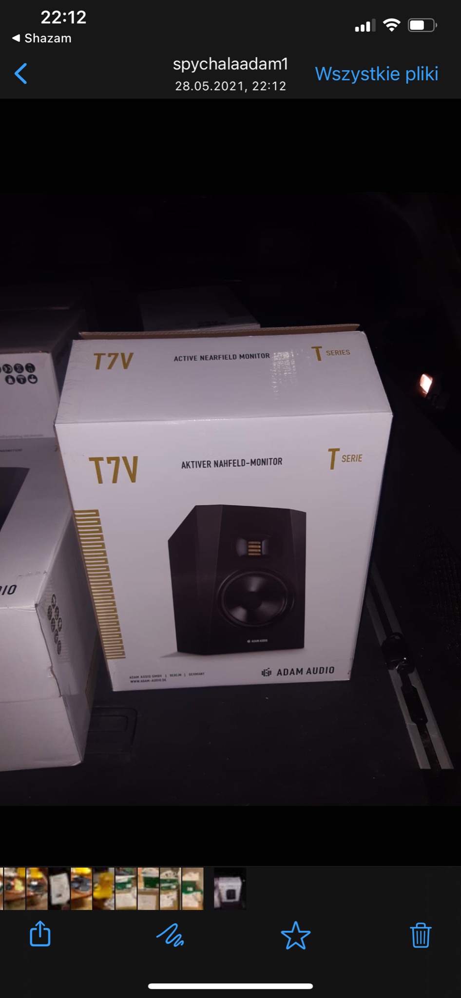 Pudełko z aktywnym monitorem bliskiego pola Adam Audio T7V, widoczne w przestrzeni ładunkowej pojazdu.