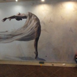 Top -Tap ..tapeta ,malowanie powierzchni - Naklejona na ścianie fototapeta z motywem baleriny w tańcu i ptaków w tle, widoczna osoba w trakcie pracy przy wygładzaniu tapety, na podłodze leżą narzędzia.