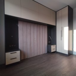 As Meble Radom - Nowoczesna sypialnia z zabudową meblową: szafa, szafki nocne i panel tapicerowany za łóżkiem w odcieniach beżu i grafitu, minimalistyczne uchwyty.