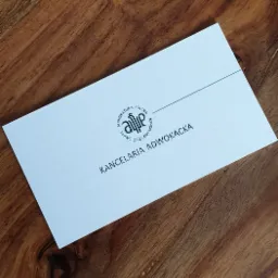 Wizytówka Kancelarii Adwokackiej z logo na drewnianym tle.