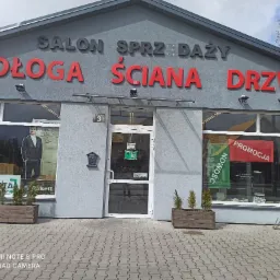 Fasada salonu sprzedaży drzwi 'Długa Ściana Drzwi' przy ulicy Mickiewicza 3 w Bielsku Podlaskim, z widocznymi ekspozycjami w oknach i informacją o promocji.