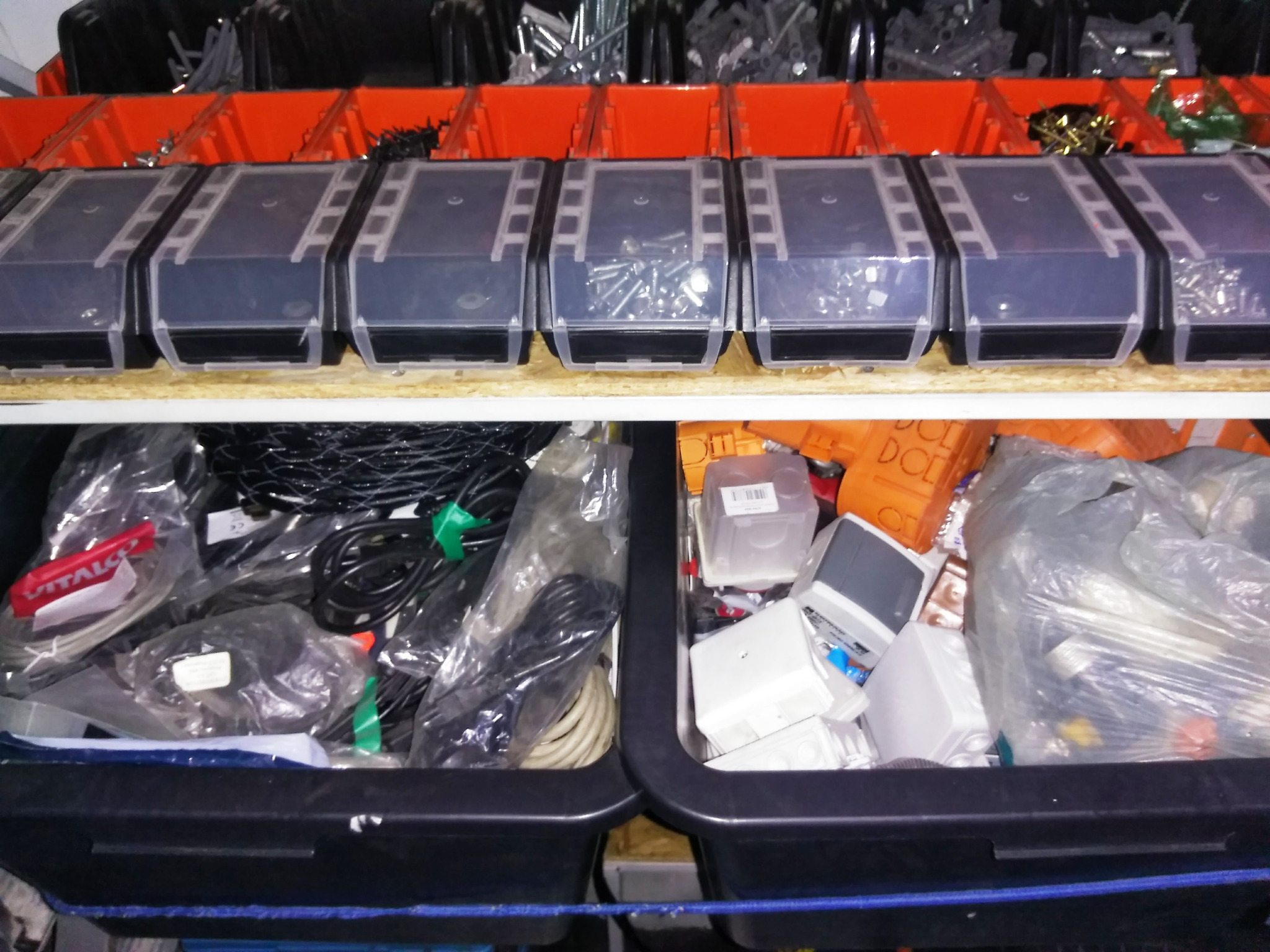 Półki z pojemnikami na drobne elementy elektryczne: śruby, kable w folii, puszki instalacyjne i inne akcesoria.