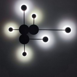 InwestAD Andrzej Dyki - Nowoczesna lampa sufitowa z okrągłymi kloszami w stylu atomu, zamontowana w Tyszowcach. Czarna konstrukcja i jasne światło tworzą unikalny efekt.