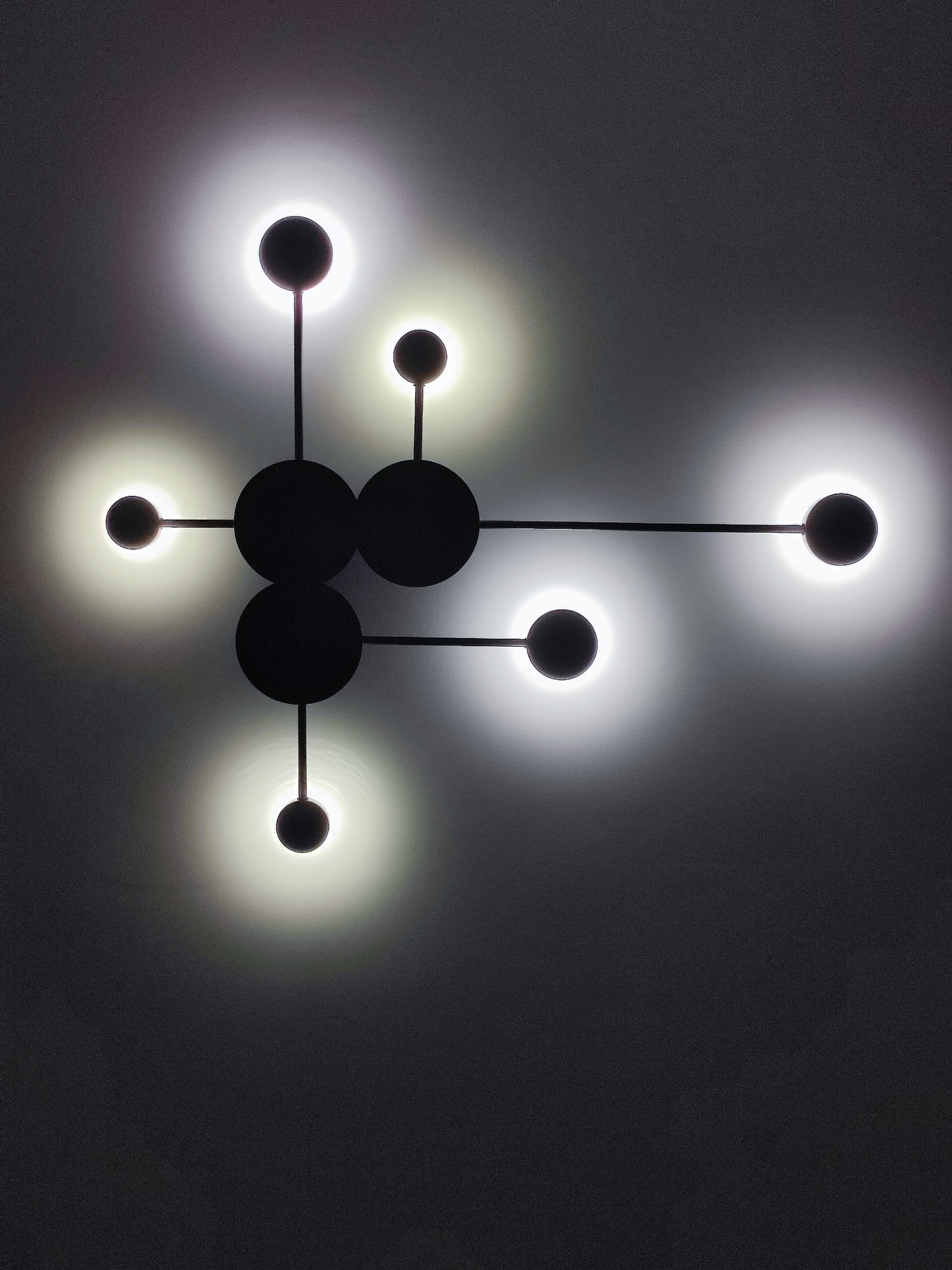 Nowoczesna lampa sufitowa z okrągłymi kloszami w stylu atomu, zamontowana w Tyszowcach. Czarna konstrukcja i jasne światło tworzą unikalny efekt.