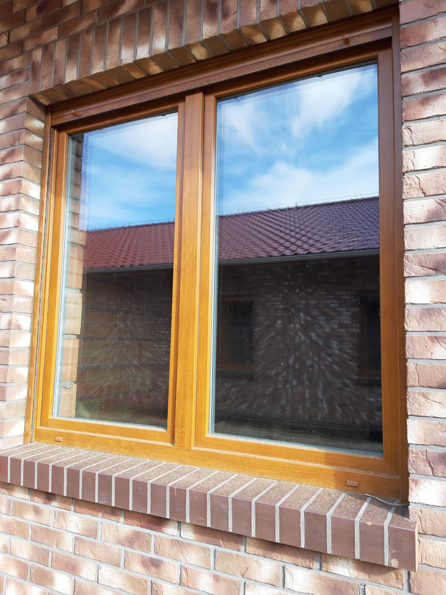 Okno + roleta zewnętrzna. Ściana: klinkier.