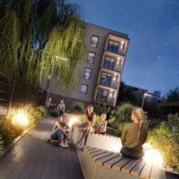 Nocny widok na nowoczesny budynek mieszkalny z oświetlonym dziedzińcem, gdzie siedzą ludzie. W tle księżyc i gwiazdy.