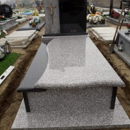 J&K JÓZEFKO - Nowo postawiony, jasnoszary nagrobek z ciemnoszarą tablicą i krzyżem, otoczony świeżo wykopaną ziemią na cmentarzu w mglisty dzień.