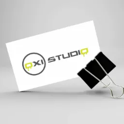 Wizytówka z logo 'OXI Studio' przypięta czarnym klipsem na jasnoszarym tle.