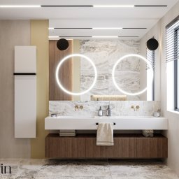 Klein Interiors Julia Klein - Nowoczesna łazienka z podwójną umywalką, okrągłymi lustrami z podświetleniem LED, marmurowymi płytkami, drewnianą szafką pod umywalką i minimalistycznymi bateriami w kolorze złota.