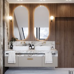 Klein Interiors Julia Klein - Nowoczesna łazienka z dwoma umywalkami nablatowymi, marmurowym blatem, owalnymi lustrami z podświetleniem LED, drewnianą okładziną ścienną i szarą szafką pod umywalką z złotymi uchwytami.