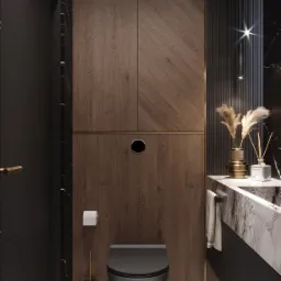 Nowoczesna łazienka z drewnianą okładziną ściany w jodełkę, wiszącą toaletą w kolorze grafitowym, marmurową umywalką i złotymi akcentami.