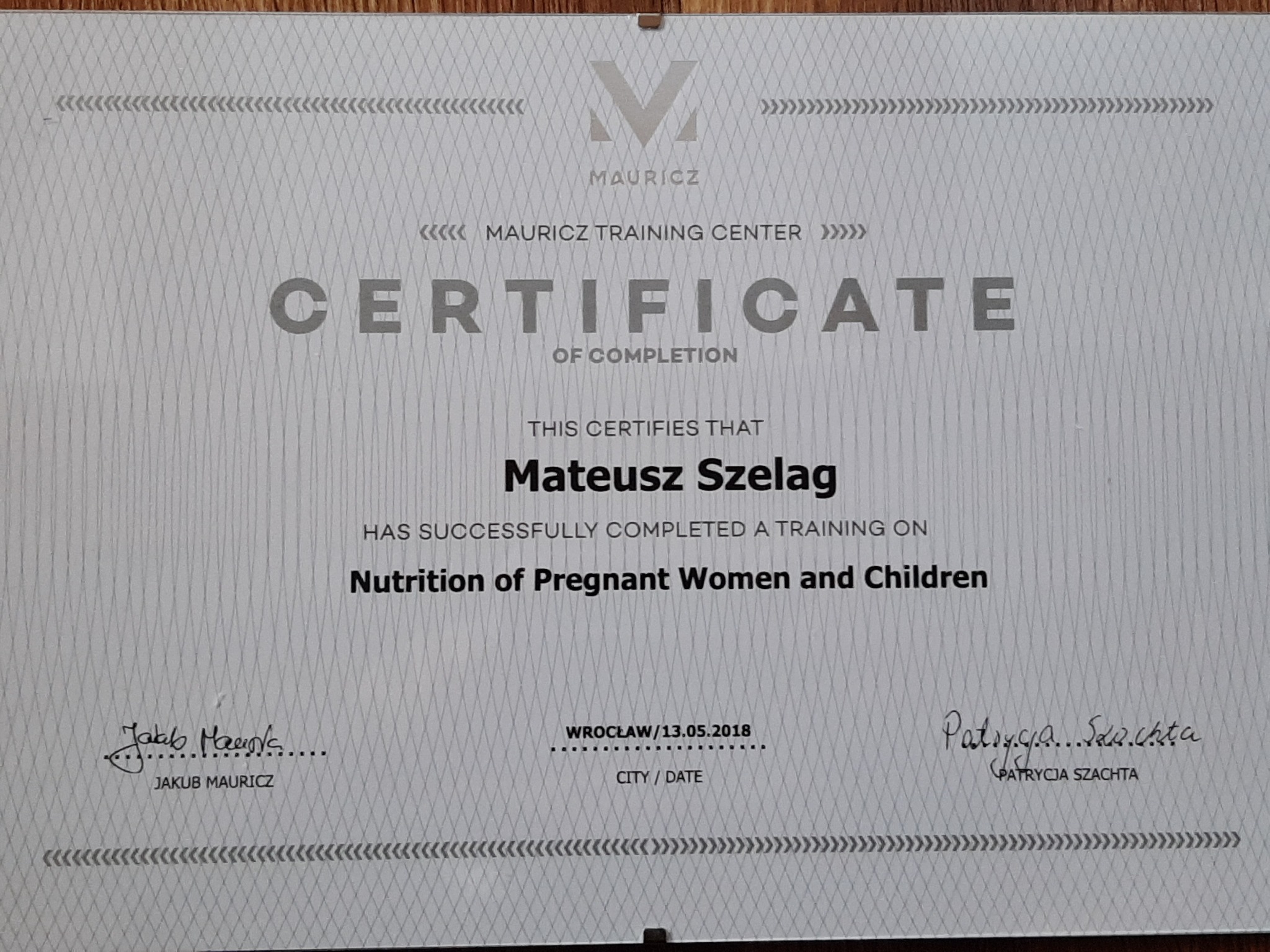 Certyfikat ukończenia szkolenia z zakresu żywienia kobiet w ciąży i dzieci, wystawiony przez Mauricz Training Center dla Mateusza Szeląga, podpisany przez Jakuba Mauricza i Patrycję Szachtę...