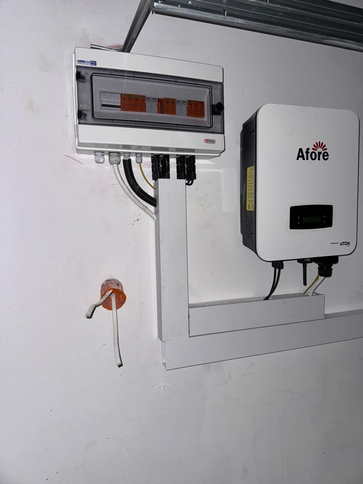 Rozdzielnica elektryczna Vesto i falownik Afore zamontowane na ścianie, widoczne przewody i peszel. Instalacja wewnątrz budynku.