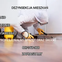 Osoba w kombinezonie ochronnym, rękawicach i masce opryskuje listwę przypodłogową za pomocą lancy z opryskiwaczem; w tle białe szafki i żółty zbiornik z opryskiwaczem. Na zdjęciu widoczny tekst...