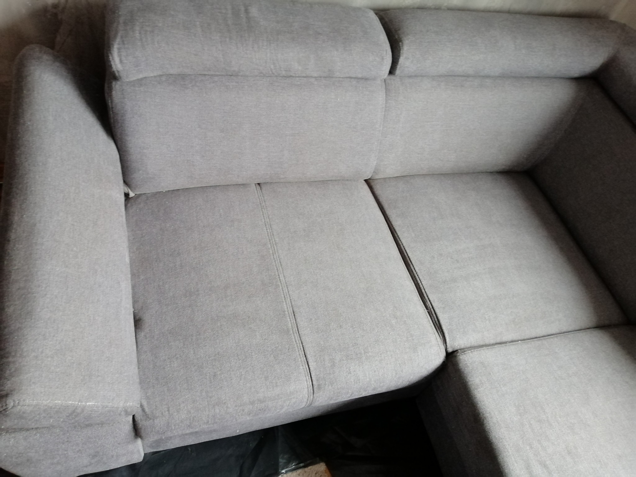 Szara, narożna kanapa z regulowanymi zagłówkami, widoczna z góry, prezentująca czystą tapicerkę.