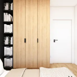 Sypialnia z drewnianą szafą w zabudowie i czarnym regałem na książki, widok na białe drzwi i podłogę z jasnego drewna, minimalistyczny styl.