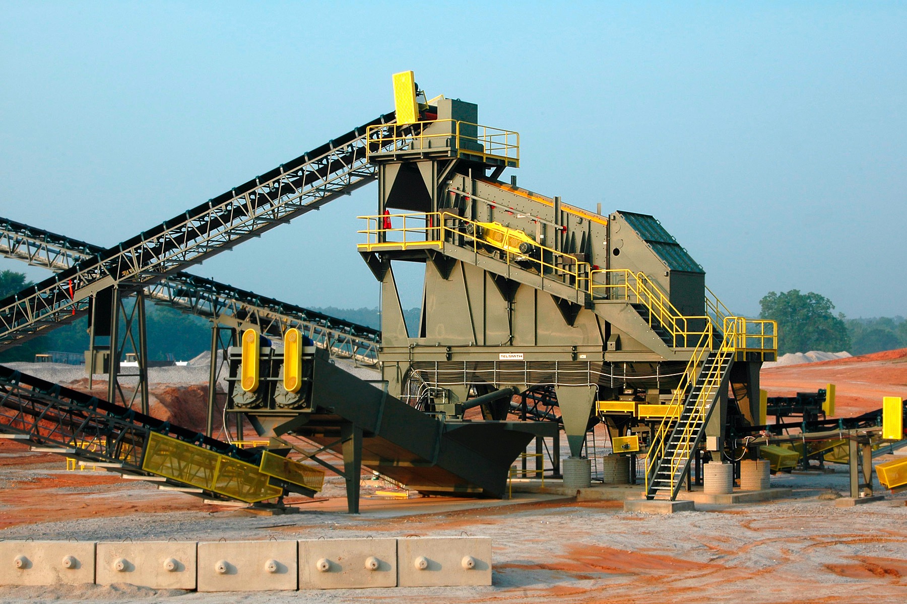 Kompleksowa instalacja do przesiewania i sortowania materiałów sypkich z systemem taśmociągów na placu budowy.