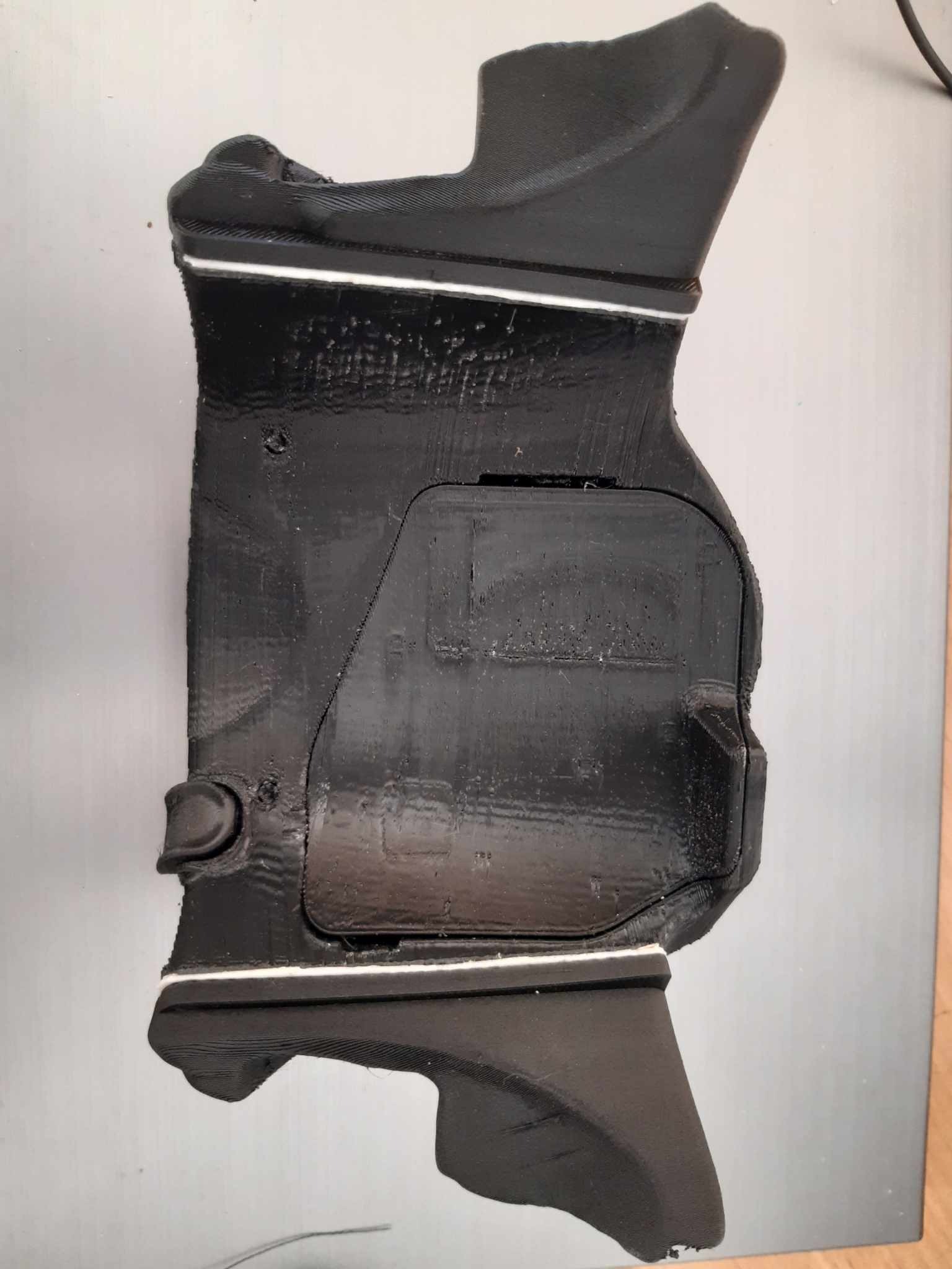 Czarny, prototypowy model obudowy wykonany metodą druku 3D, widoczne warstwy materiału i niedoskonałości powierzchni.