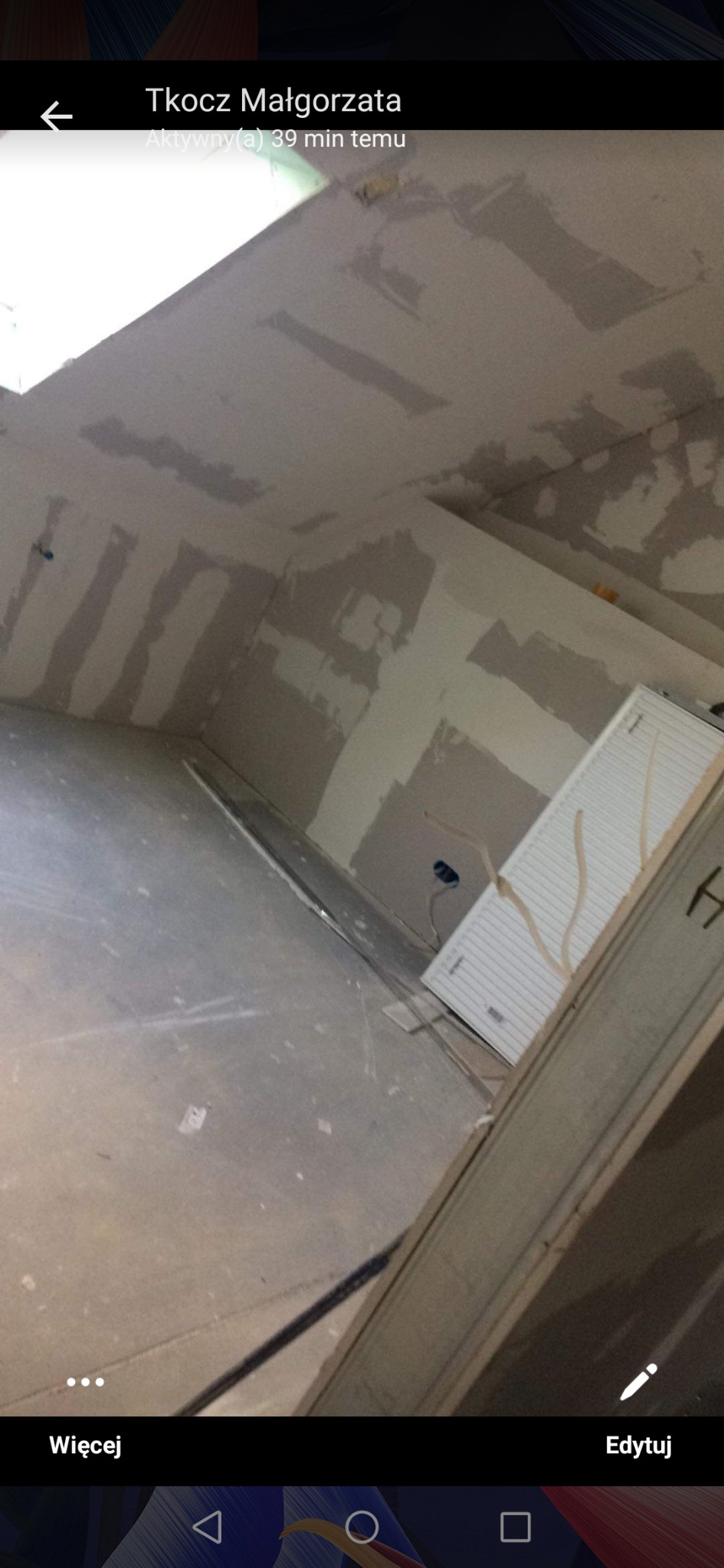 Ściany w trakcie przygotowania do malowania, widoczne ślady po szpachlowaniu, grzejnik i fragment ościeżnicy.