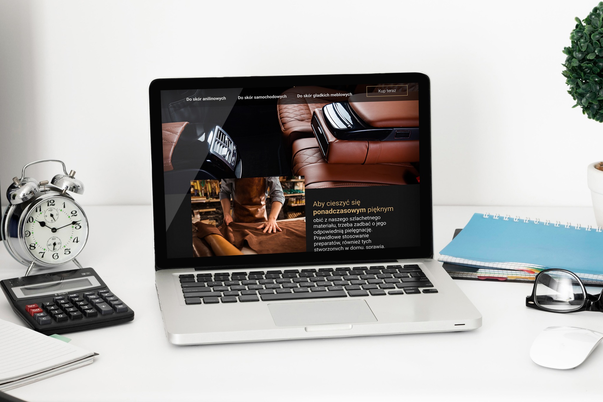Laptop wyświetla stronę internetową z ofertą pielęgnacji skórzanych obić, widoczne skórzane fotele samochodowe i rzemieślnik pracujący ze skórą, obok biurko z zegarem, kalkulatorem i notatnikiem.