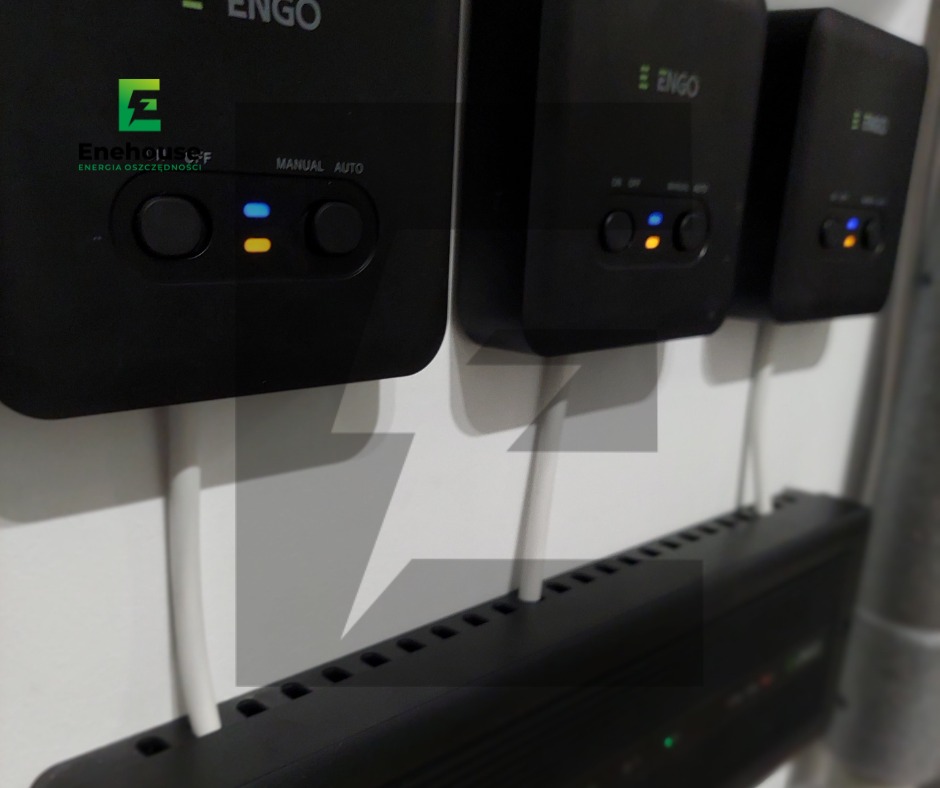 Czarny falownik ENGO z diodami LED w Kołobrzegu. Urządzenie podłączone białym kablem, widoczne otwory wentylacyjne i logo firmy Enehouse.