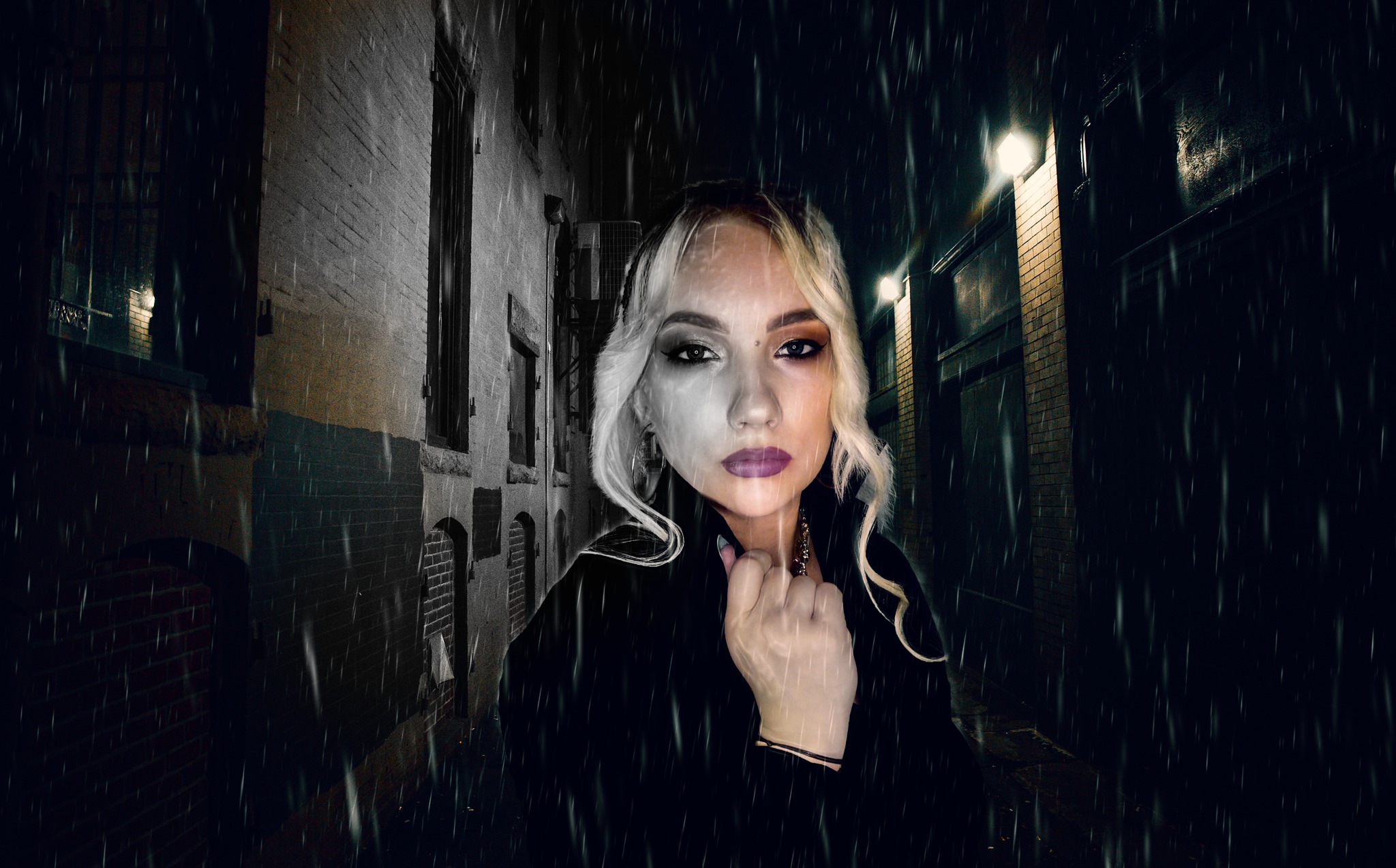 Portret kobiety z makijażem w stylu dualizmu, połowa twarzy w kolorze, druga czarno-biała, na tle miejskiej uliczki w deszczu i nocnym oświetleniu.