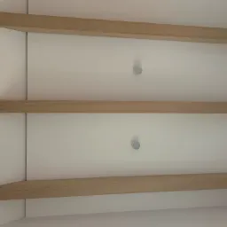 Nowoczesny sufit z trzema poziomami drewnianych belek i punktowym oświetleniem LED, widok z dołu.