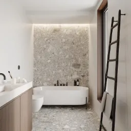 Minimalistyczna łazienka z wanną wolnostojącą, umywalką nablatową z szafką z drewnopodobnym frontem oraz czarną drabinką na ręczniki przy oknie.