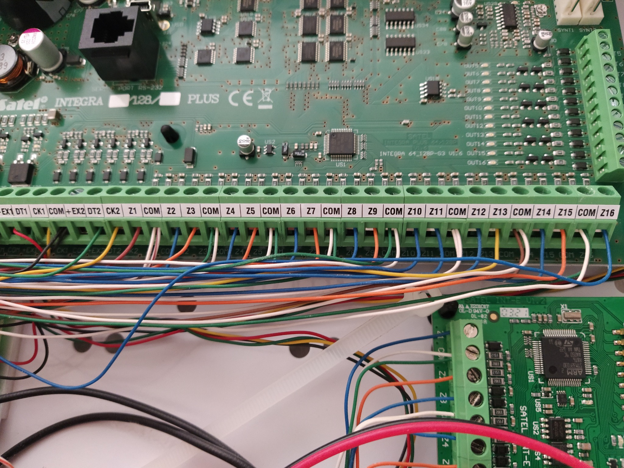 Centrala alarmowa Satel Integra 128 Plus z podłączonymi przewodami instalacji alarmowej, widoczne złącza Z1-Z16, montaż w Warszawie.