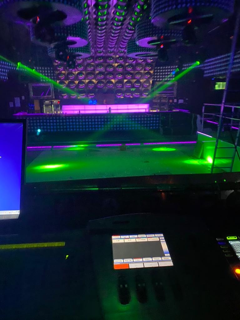 Oświetlenie dyskotekowe z zielonymi laserami i panelem sterowania oświetleniem w pierwszym planie.