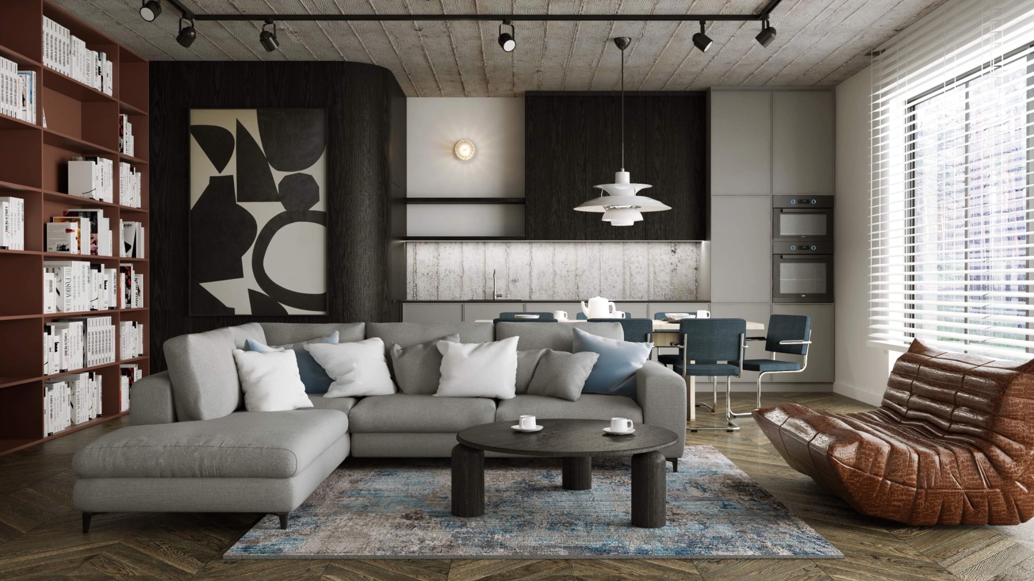 Salon z szarą sofą narożną, okrągłym stolikiem kawowym z dwoma filiżankami, regałem z książkami, abstrakcyjnym obrazem i jadalnią w tle, oświetlony lampą wiszącą i światłem dziennym.