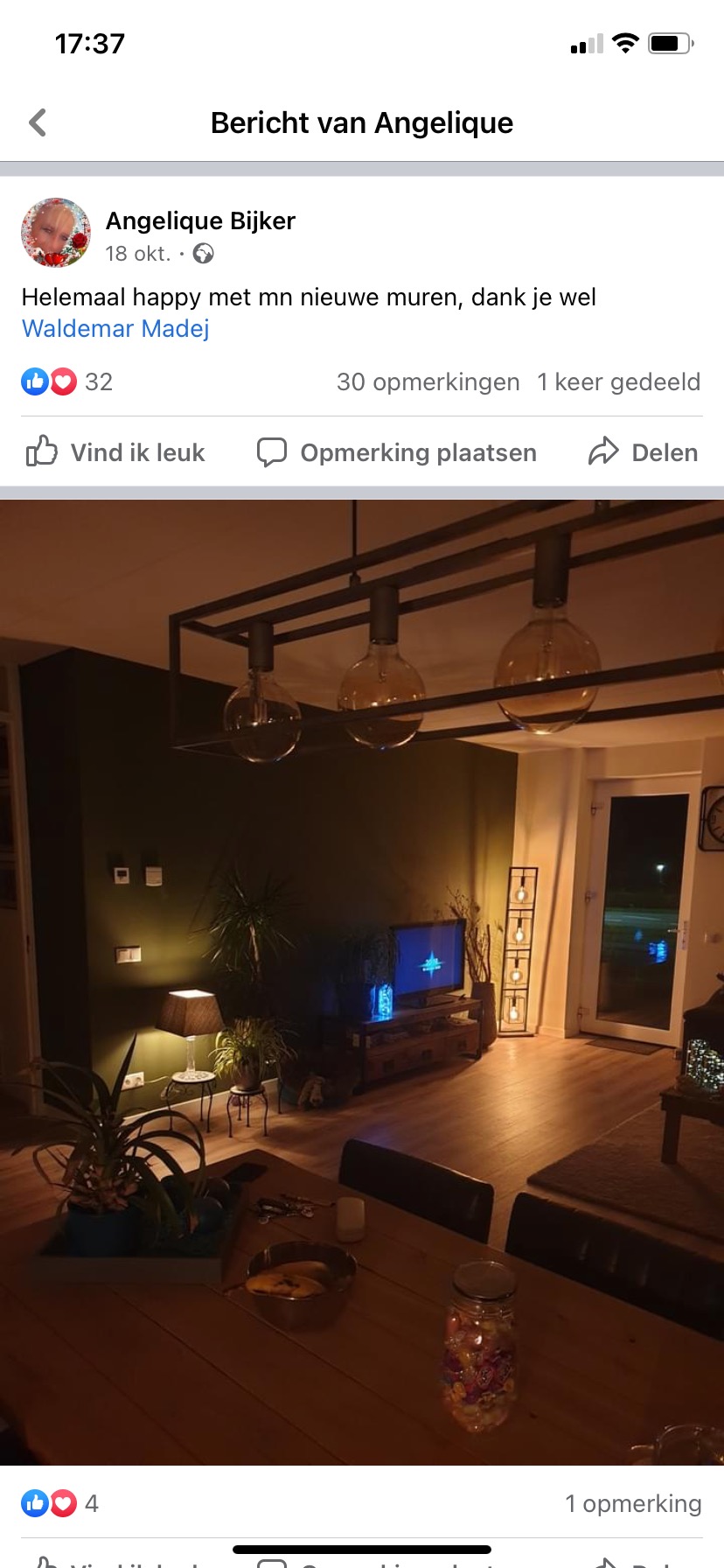 Pokój po remoncie z ciemnozielonymi ścianami, oświetlony lampą z trzema żarówkami Edisona, widok z perspektywy stołu z miską i słoikiem.