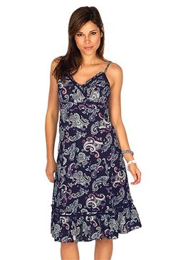 Kobieta w letniej, granatowej sukience na ramiączkach z wzorem paisley, stojąca na białym tle.