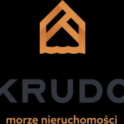 Logo firmy KRUDO morze nieruchomości z abstrakcyjnym symbolem domu nad falami w kolorze ciepłego brązu na czarnym tle.