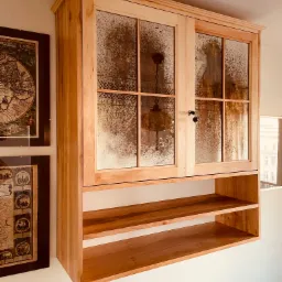 Szafka z drewna olchowego, wykańczana lustrem postarzanym.