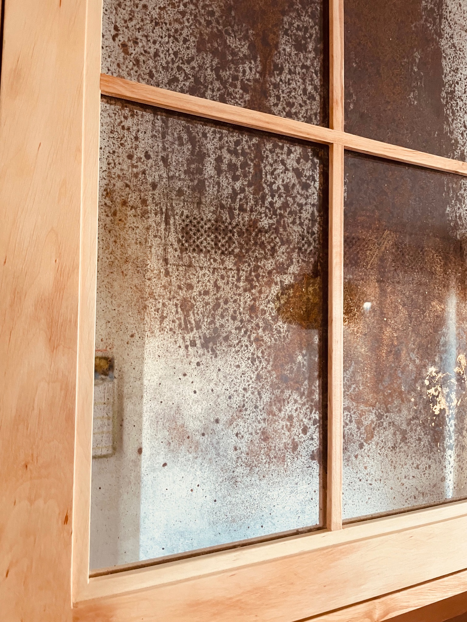 Szafka z drewna olchowego, wykańczana lustrem postarzanym.