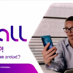 Kobieta w okularach robiąca wideokonferencję na smartfonie, siedząc przy biurku z laptopem w jasnym biurze. W tle logo firmy Oxcall.