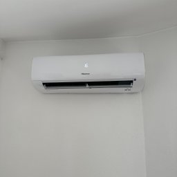 Eko-Klima Krzysztof Żochowski - Biała klimatyzacja Hisense z wyświetlaczem temperatury 16 stopni Celsjusza, zamontowana na jasnej, teksturowanej ścianie w pomieszczeniu.