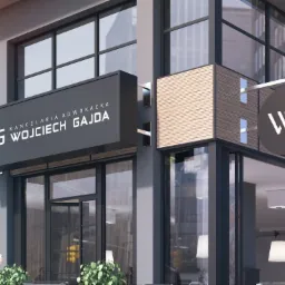 Elegancki szyld i okrągły znak z logo 'WG' na fasadzie nowoczesnej kancelarii adwokackiej Wojciech Gajda, widok z zewnątrz, z przechodniami i roślinami w tle.