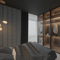 Hektar Studio Projektowe - Nowoczesna sypialnia w ciemnych barwach z tapicerowanym zagłówkiem i trzema owalnymi lampami wiszącymi. Obok przeszklona garderoba z podświetlanymi półkami i ubraniami.