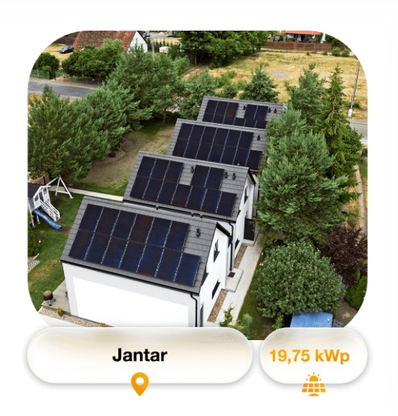 Widok z góry na szereg domów jednorodzinnych z panelami słonecznymi na dachach, otoczonych zielenią, z informacją o nazwie 'Jantar' i mocy 19,75 kWp.
