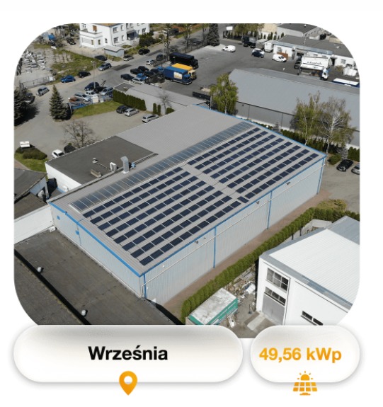 Widok z góry na dużą instalację paneli słonecznych na dachu magazynu przemysłowego we Wrześni, z informacją o mocy 49,56 kWp i parkingiem z samochodami w tle.