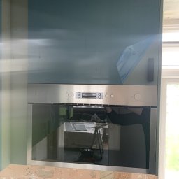 Dawid Szpejenkowski - Nowa zabudowa kuchenna z piekarnikiem w trakcie montażu, widoczne ślady po szpachlowaniu na ścianie i folia ochronna na szafce.