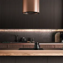 Nowoczesna kuchnia w ciemnych odcieniach brązu z drewnianym blatem wyspowym, miedzianym okapem cylindrycznym i oświetleniem LED pod szafkami.