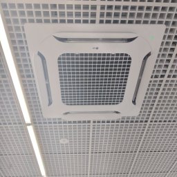 Klim System - Kasetonowa jednostka klimatyzacyjna LG zamontowana w suficie podwieszanym, widoczna zielona dioda sygnalizacyjna.