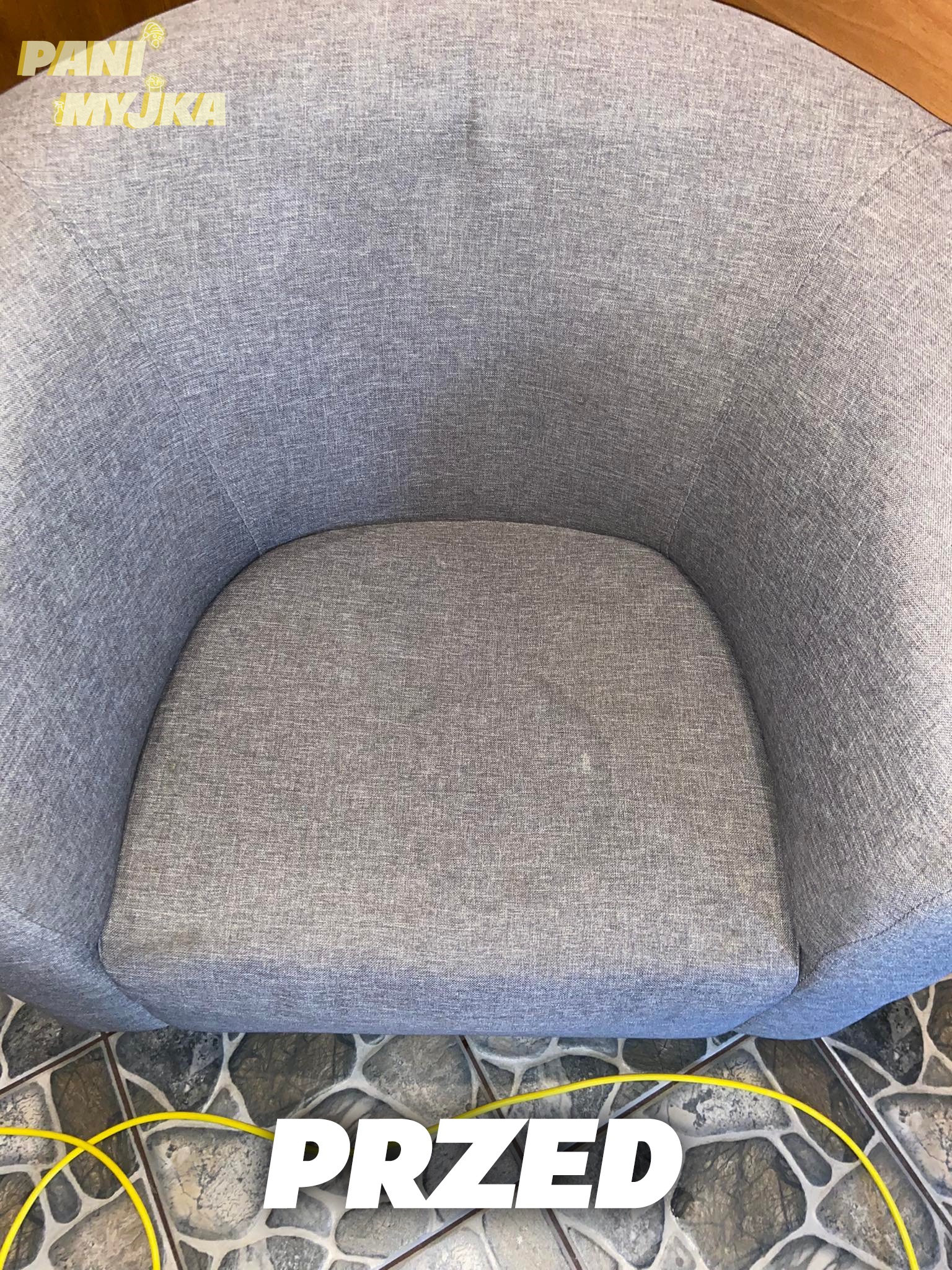 Szare, tapicerowane krzesło w ujęciu z góry, z widocznymi plamami na siedzisku i napisem 'PRZED' sugerującym stan przed czyszczeniem.