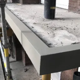 Świeżo wykonana wylewka na balkonie z widoczną konstrukcją szalunkową i pozostałościami po budowie.