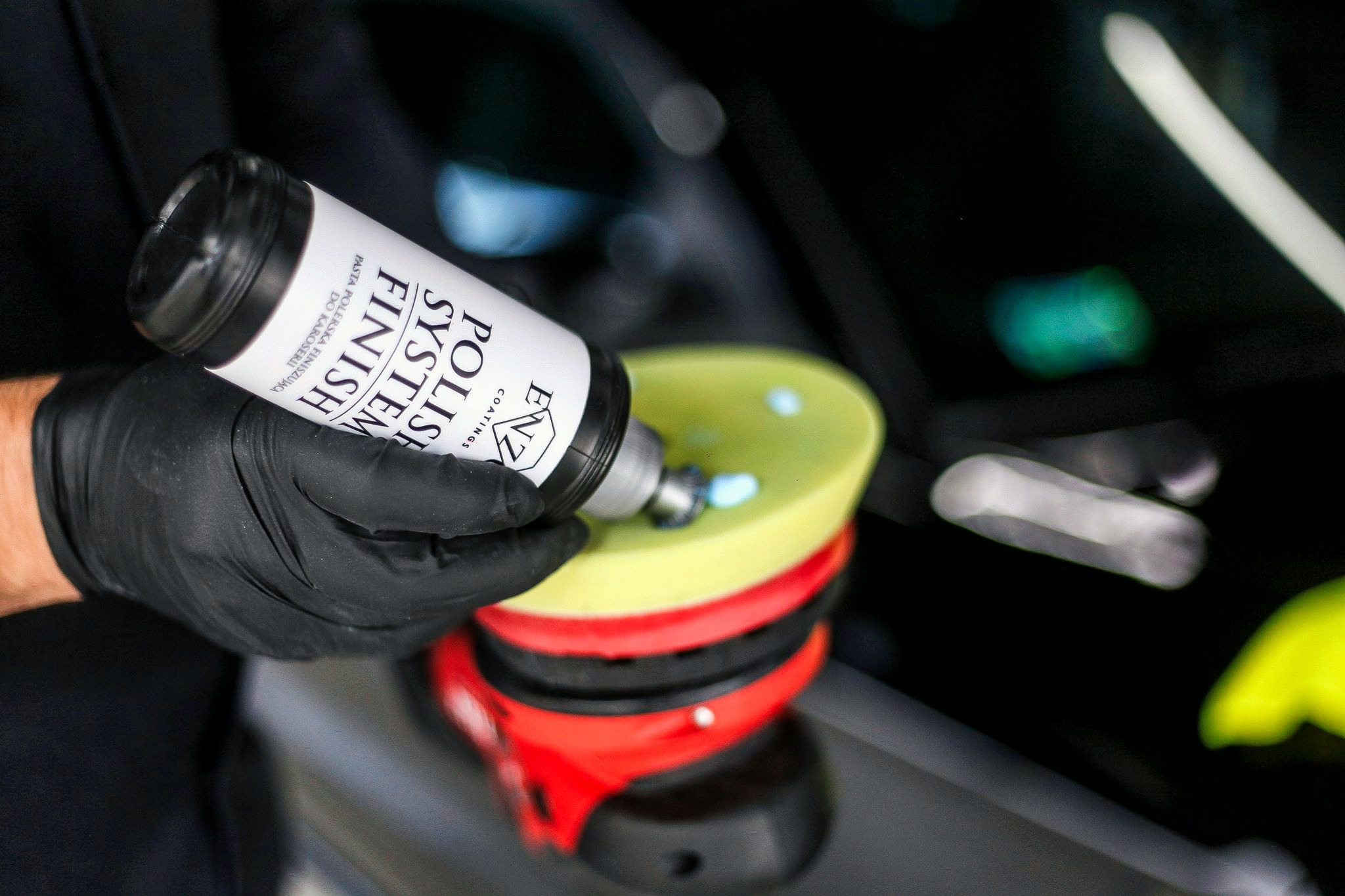 Nakładanie pasty polerskiej 'Polish System Finish' na żółtą gąbkę polerską, przygotowanie do polerowania lakieru samochodowego.